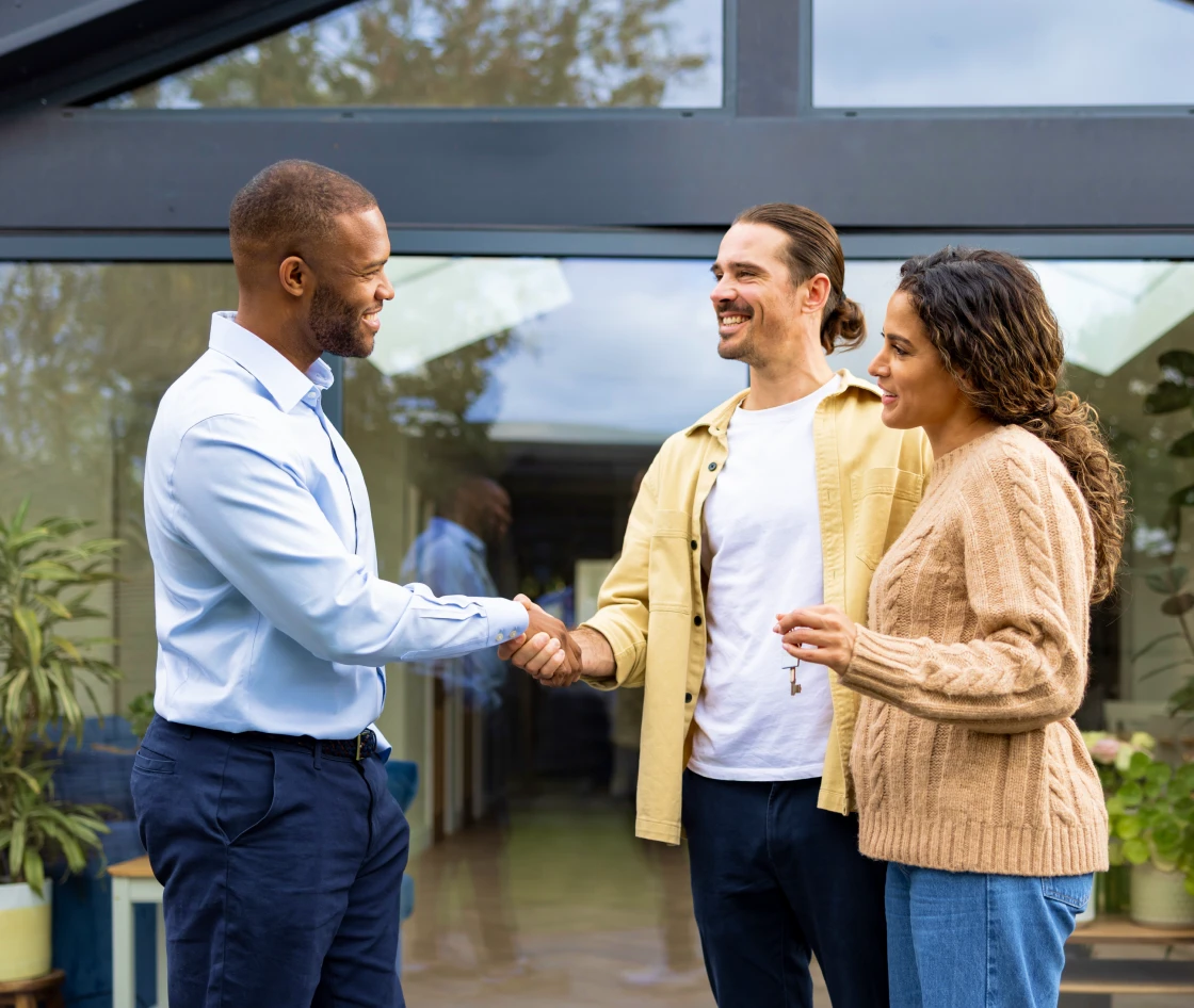 Real estate agent handing keys to couple